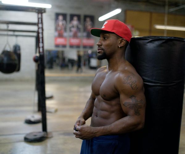 Focused man resting between exercise sets in a gym.